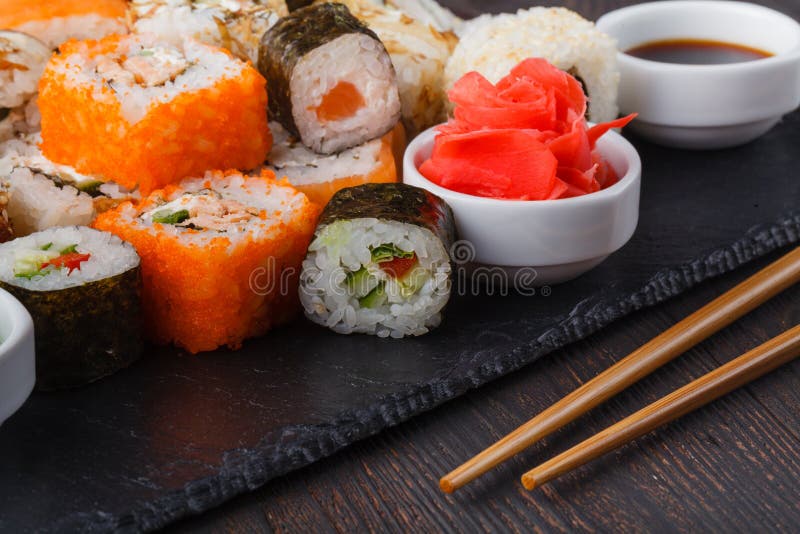 Pile of Various kinds of sushi served on black stone