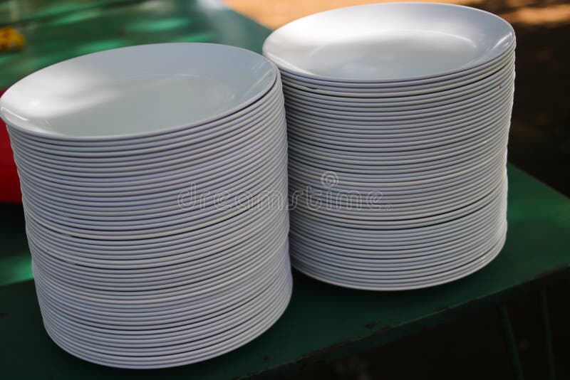 A Pile of White Clean Plates on a Buffet Table at an Outdoor Wedding