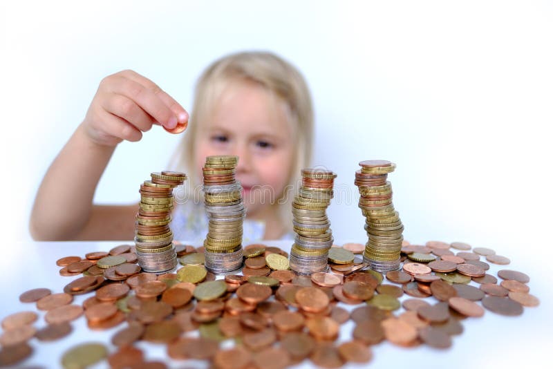 Stacks of euro currency coins, small child, blonde girl 3 years old playing with cash, pocket money against white background, concept of financial literacy of children, inflation, personal savings. Stacks of euro currency coins, small child, blonde girl 3 years old playing with cash, pocket money against white background, concept of financial literacy of children, inflation, personal savings