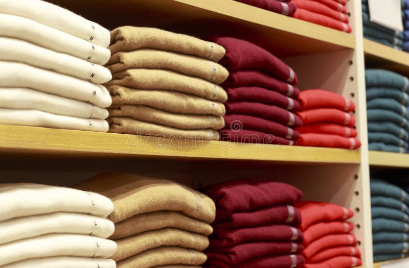 Piles of Multicolored Clothes on the Shelves in Store Stock Image