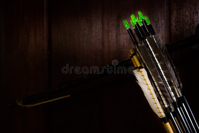 Arrow fletchings in different variation wwith bow on wooden wall. Arrow fletchings in different variation wwith bow on wooden wall