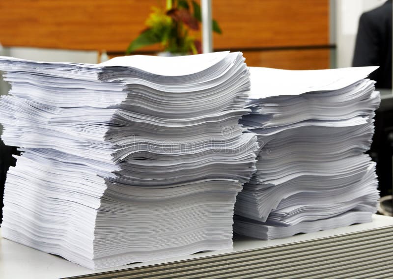 A pilha de papel no escritório como um símbolo da burocracia e dos funcionários públicos fotografia de stock A pilha de papel no escritório como um símbolo da burocracia e dos funcionários públicos fotografia de stock