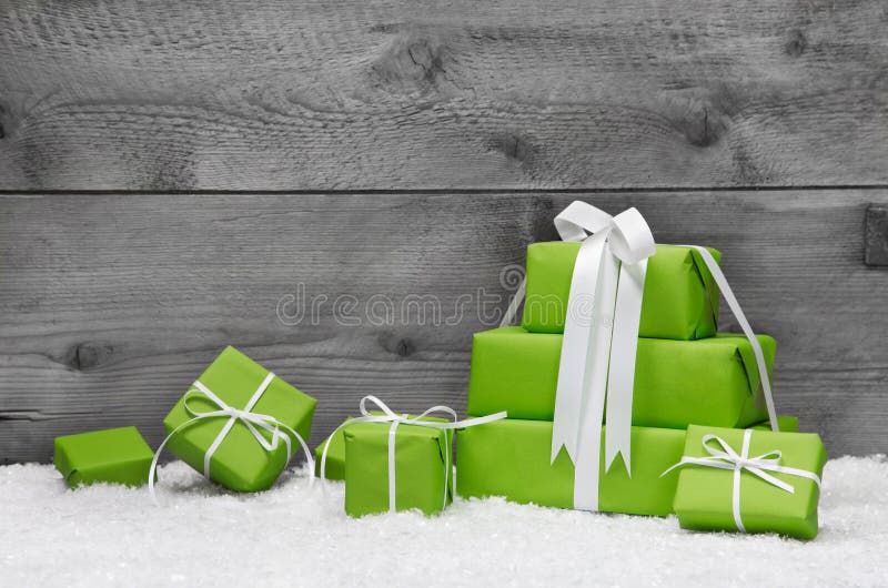 Pilha de presentes de Natal verdes, com neve num fundo cinzento imagem de stock royalty free