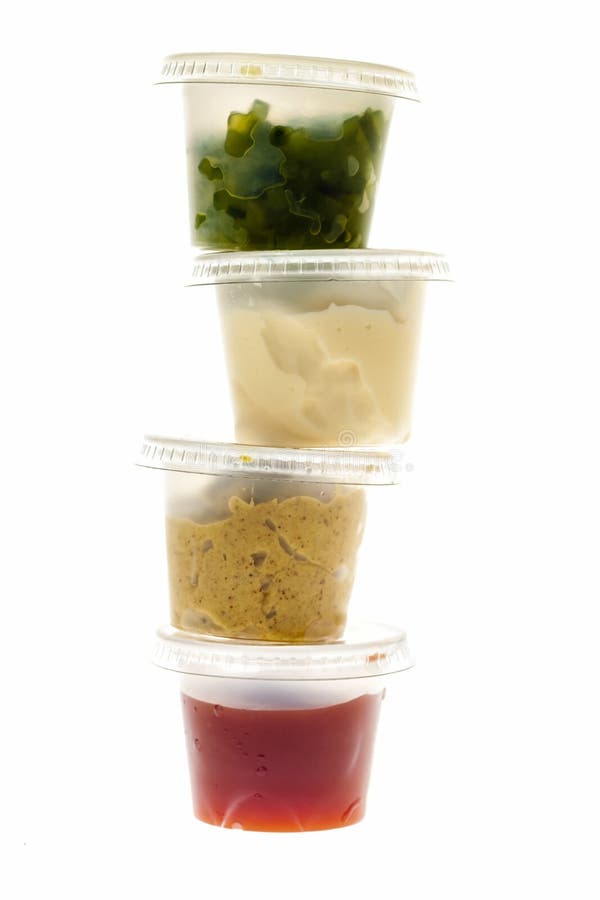 Relish mustard ketchup and mayonnaise condiments in clear containers stacked on white background. Relish mustard ketchup and mayonnaise condiments in clear containers stacked on white background