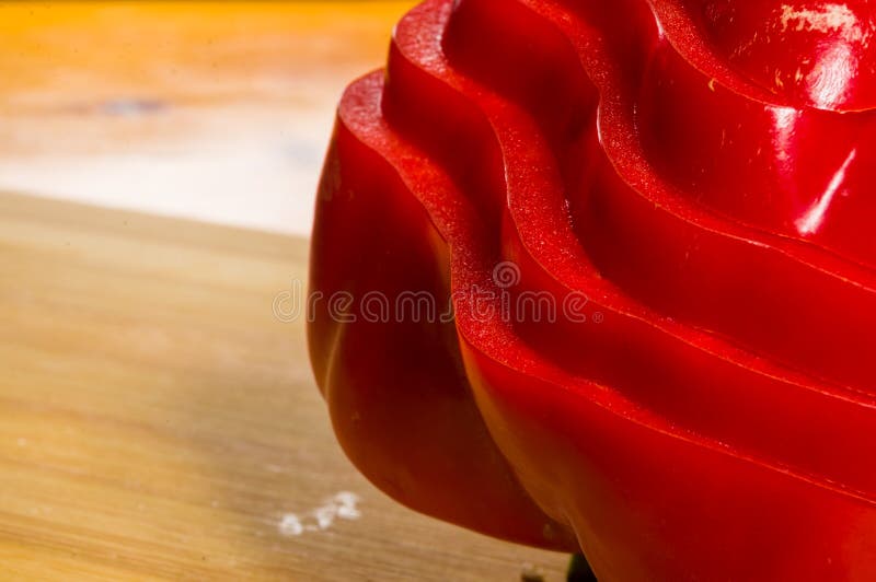 Pilha empilhada da paprika vermelha fresca cortada, pimenta de sino na placa de corte de bambu imagem de stock royalty free