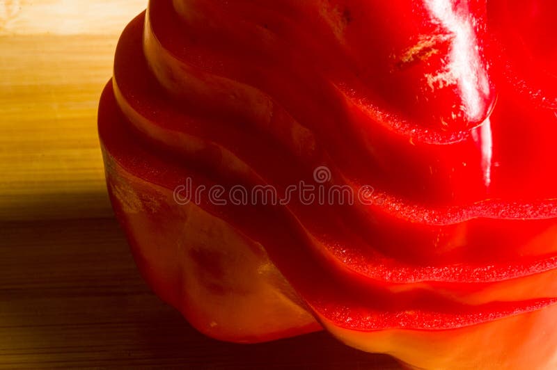 Pilha empilhada da paprika vermelha fresca cortada, pimenta de sino na placa de corte de bambu imagem de stock