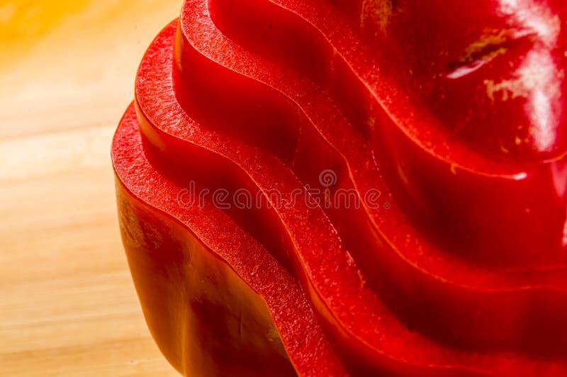 Pilha empilhada da paprika vermelha fresca cortada, pimenta de sino na placa de corte de bambu foto de stock