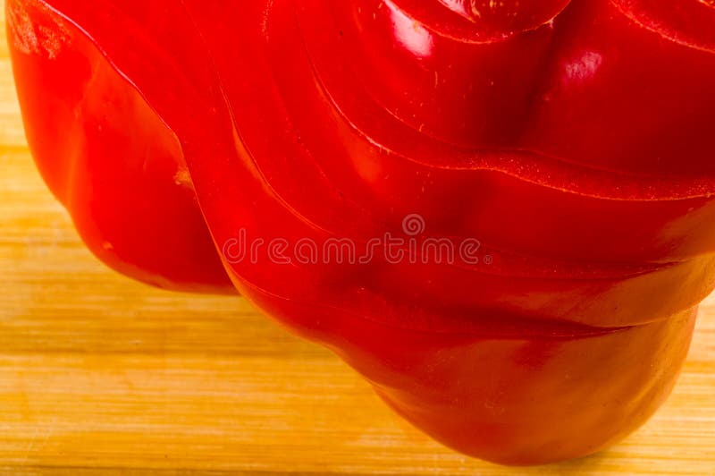 Pilha empilhada da paprika vermelha fresca cortada, pimenta de sino na placa de corte de bambu imagem de stock royalty free