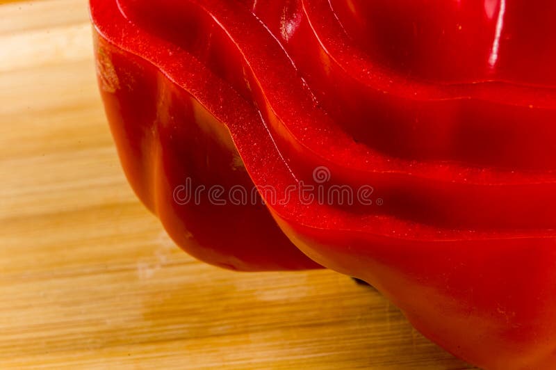 A pilha empilhada da paprika vermelha fresca cortada, pimenta de sino na placa de corte de bambu, fecha-se acima imagens de stock
