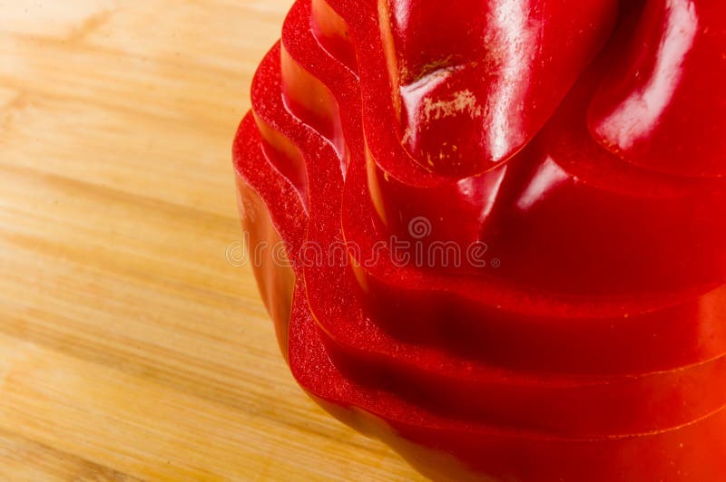 Pilha empilhada da paprika vermelha fresca cortada, pimenta de sino na placa de corte de bambu fotografia de stock
