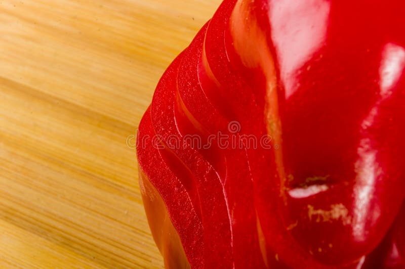 Pilha empilhada da paprika vermelha fresca cortada, pimenta de sino na placa de corte de bambu imagem de stock