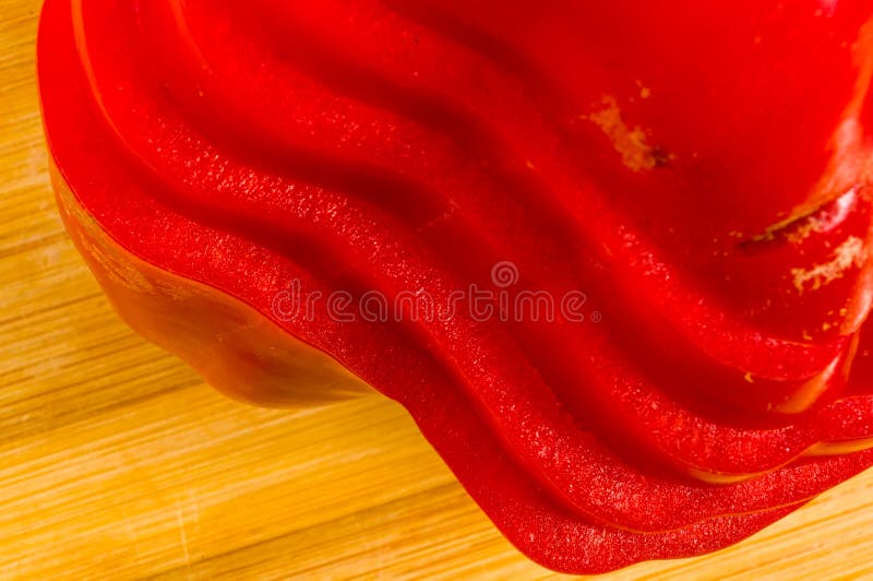 Pilha empilhada da paprika vermelha fresca cortada, pimenta de sino na placa de corte de bambu fotografia de stock