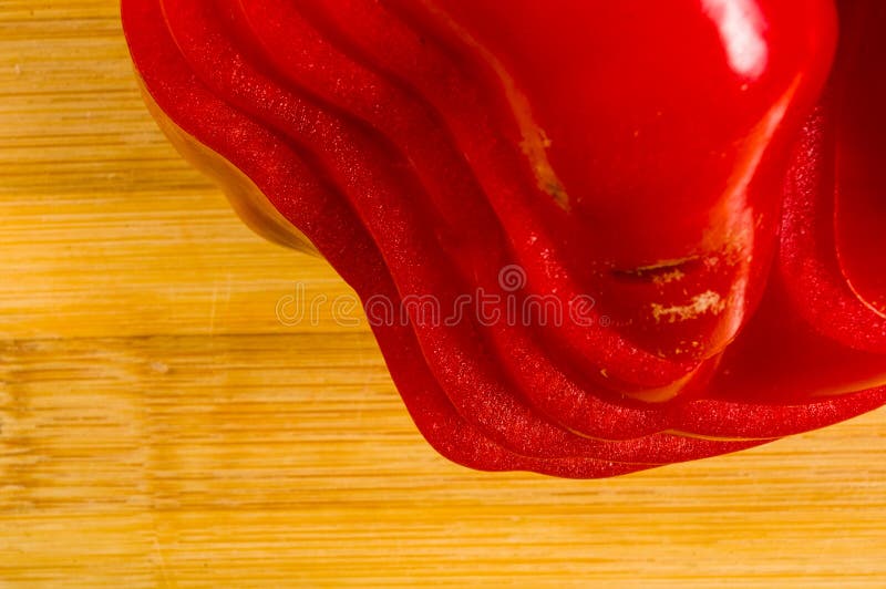 Pilha empilhada da paprika vermelha fresca cortada, pimenta de sino na placa de corte de bambu imagens de stock royalty free