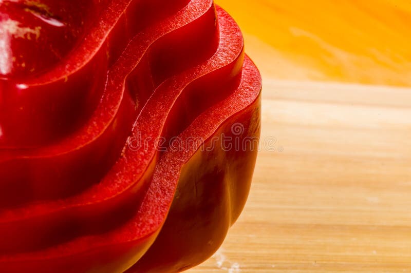 Pilha empilhada da paprika vermelha fresca cortada, pimenta de sino na placa de corte de bambu imagens de stock