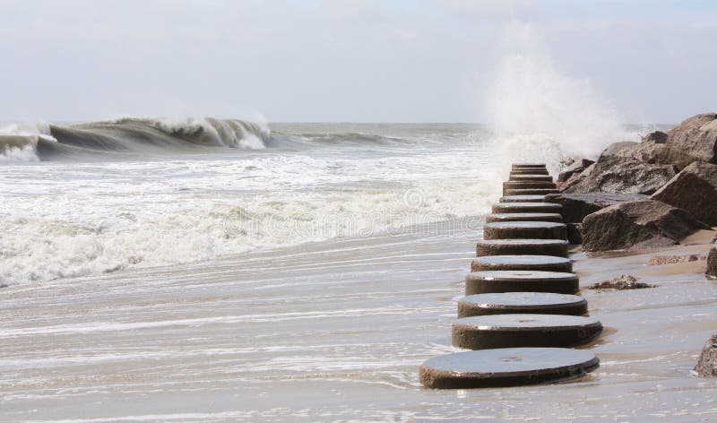 Ondas tirar la roca muelle a lo largo de Playa durante tormenta.