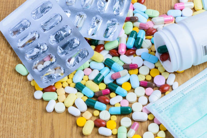 Pill Bottle Spilling Pills and Empty Blister Pack on To Surface Stock