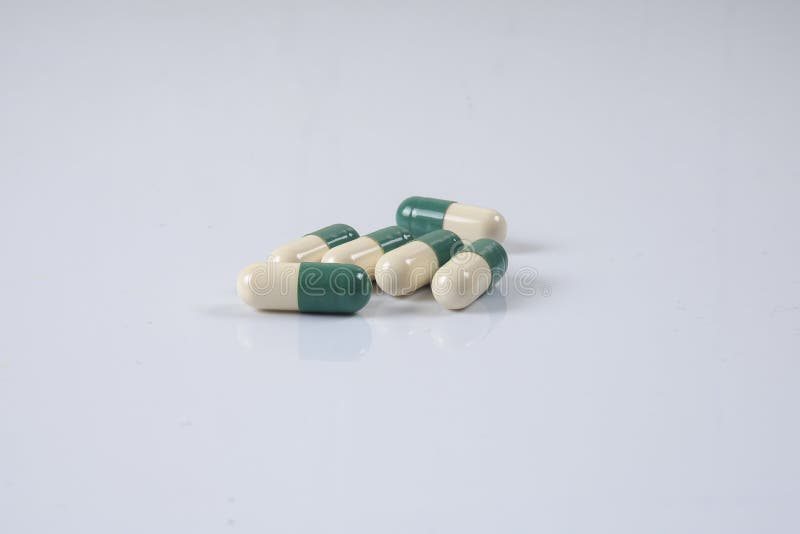 Pillole di verde/gialle medicina su bianco Sanità concettuale fotografia stock Pillole di verde/gialle medicina su bianco Sanità concettuale fotografia stock