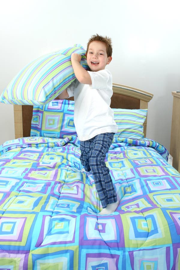 Happy five year old boy throwing pillow towards camera. Happy five year old boy throwing pillow towards camera.