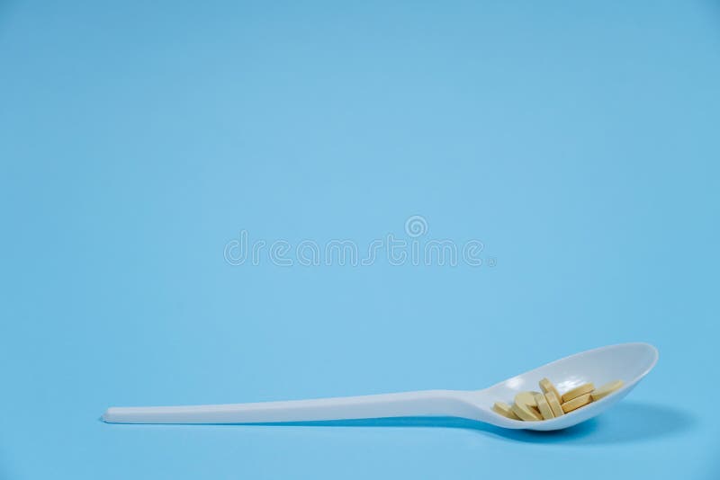 Pills on a blue background in spoon. stock images Pills on a blue background in spoon. stock images