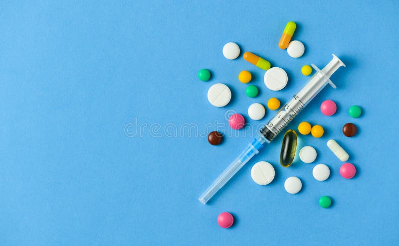 Pills on blue background, tablets, syringe, vitamins and  drugs