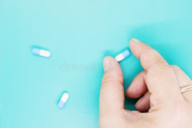 Pills in female hand, white capsules close up, pills capsules with white powder inside close up, coated medicine, medical preparat stock photography Pills in female hand, white capsules close up, pills capsules with white powder inside close up, coated medicine, medical preparat stock photography