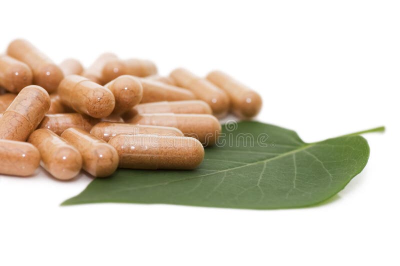 Pills on green sheet isolated on white stock photos
