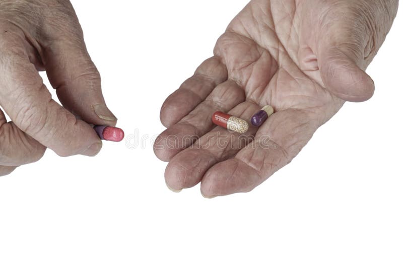 Pills on palm of a senior person