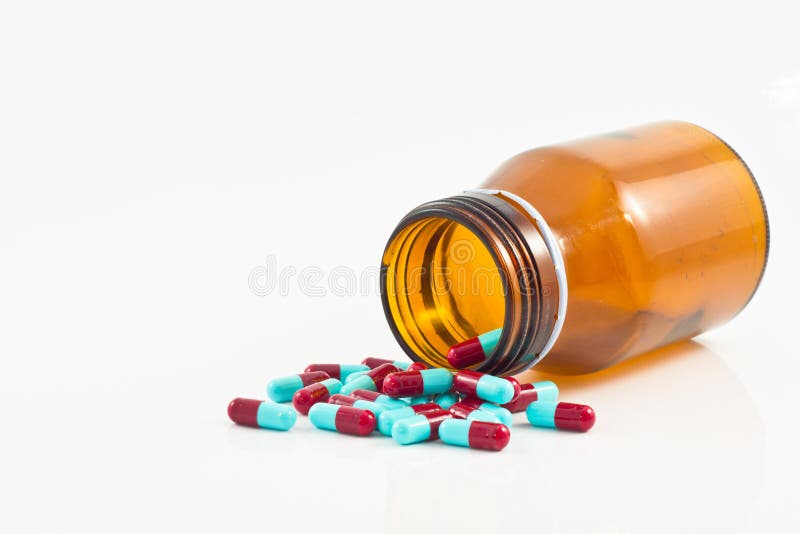 Pills pouring out of the brown bottle