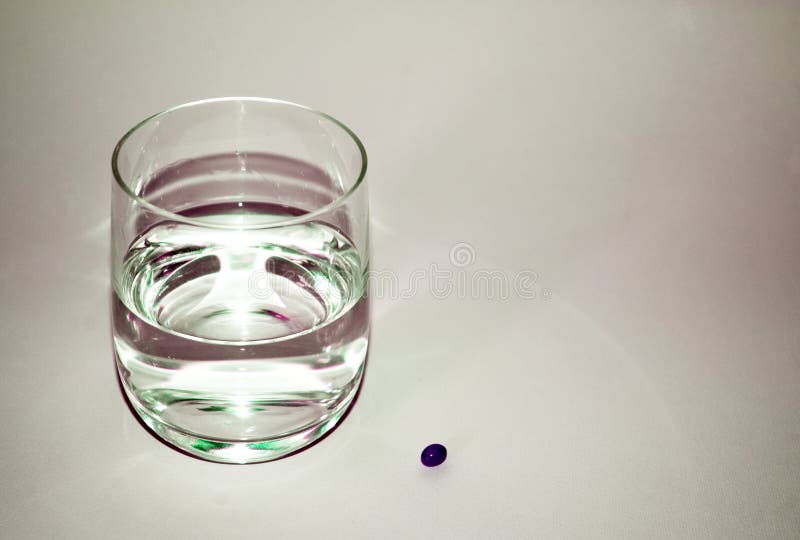 A water glass and a pill - medical concept. A water glass and a pill - medical concept