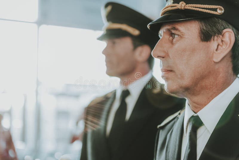 Pilot chipeș și copilot tânăr care se află în aeroport royalty free stock images