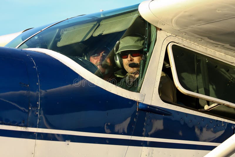 Pilot and co-pilot in cockpit of Cessna 180 stock images Pilot and co-pilot in cockpit of Cessna 180 stock images