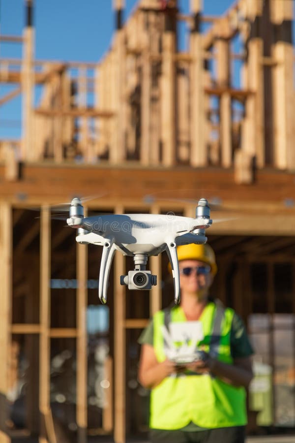 Pilota femminile Flies Drone Quadcopter che ispeziona il cantiere fotografia stock libera da diritti Pilota femminile Flies Drone Quadcopter che ispeziona il cantiere fotografia stock libera da diritti