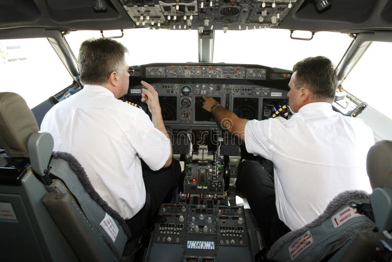 Pilotos do avião na cabina do piloto que prepara-se à decolagem