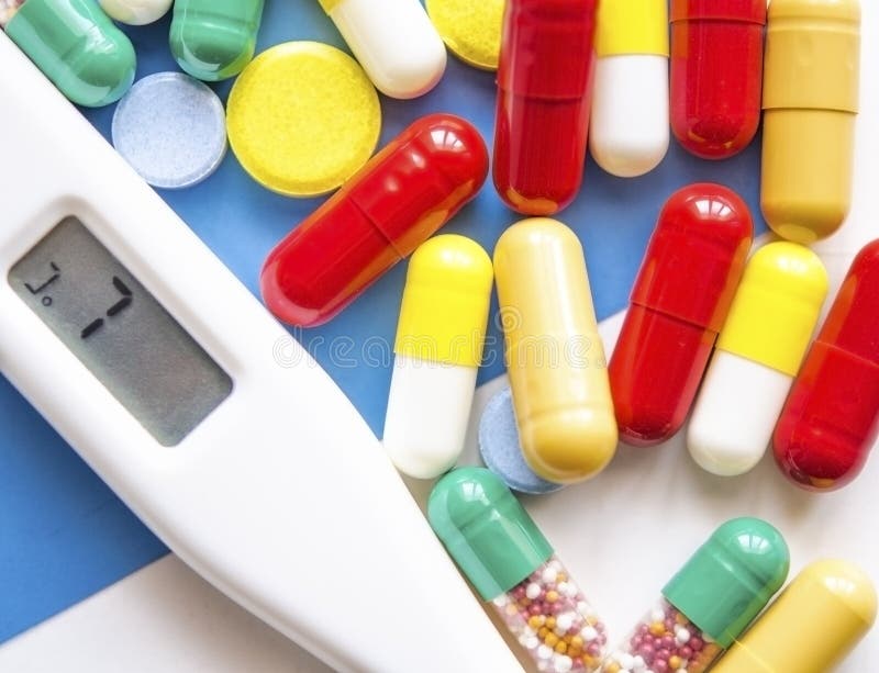 Pilules, drogues et capsules de médecine avec le thermomètre numérique photo libre de droits Pilules, drogues et capsules de médecine avec le thermomètre numérique photo libre de droits