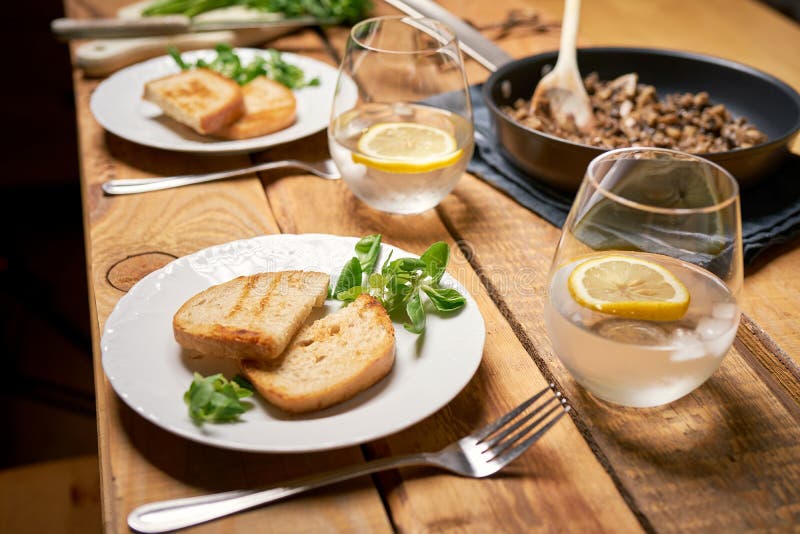 Pilze in Pfanne mit Toast und Petersilie auf Holztisch stockfoto Pilze in Pfanne mit Toast und Petersilie auf Holztisch stockfoto