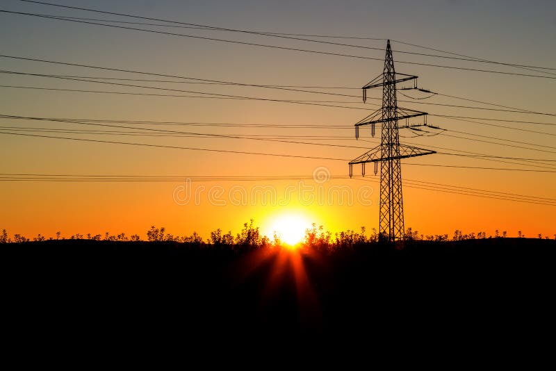 Pilón de la electricidad en la puesta del sol imágenes de archivo libres de regalías Pilón de la electricidad en la puesta del sol imágenes de archivo libres de regalías
