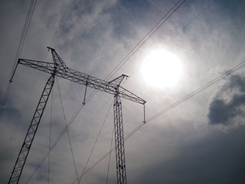 Pilón de la transmisión de la electricidad silueteado contra el cielo azul en la oscuridad foto de archivo libre de regalías Pilón de la transmisión de la electricidad silueteado contra el cielo azul en la oscuridad foto de archivo libre de regalías