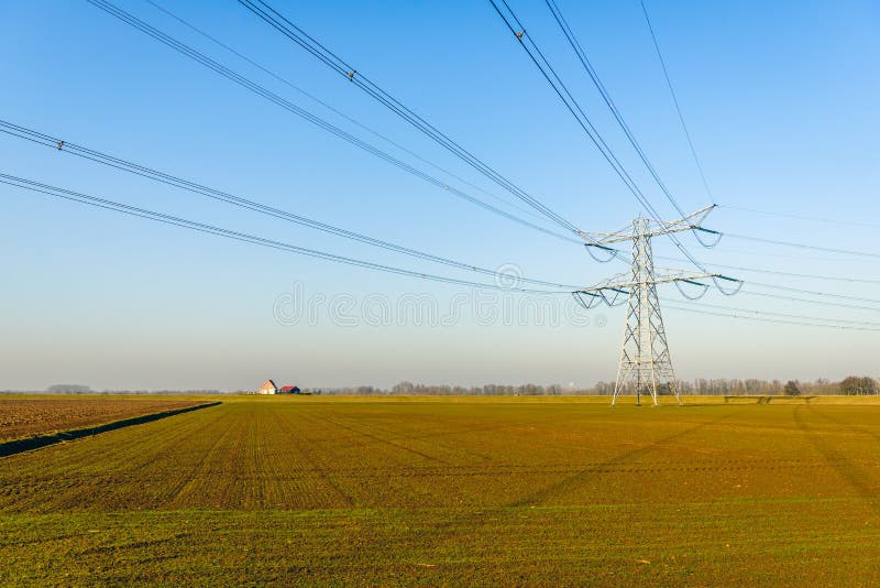 Pilón y cables de alto voltaje en un paisaje plano fotos de archivo Pilón y cables de alto voltaje en un paisaje plano fotos de archivo