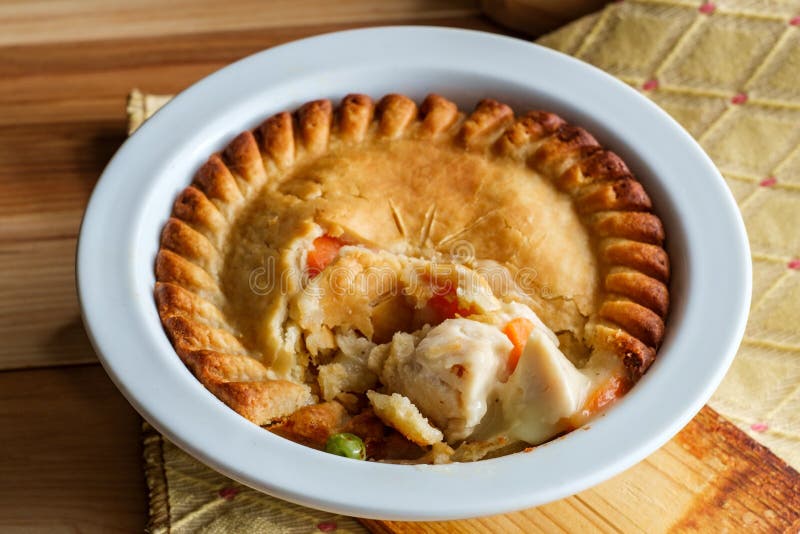 Crispy flaky baked chicken pot pie in white bowl. Crispy flaky baked chicken pot pie in white bowl