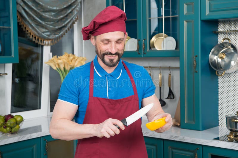 Pimenta de sino amarelo cortada indo do cozinheiro Homem do cozinheiro chefe que cozinha vegetais na cozinha Começo do homem que fotografia de stock Pimenta de sino amarelo cortada indo do cozinheiro Homem do cozinheiro chefe que cozinha vegetais na cozinha Começo do homem que fotografia de stock