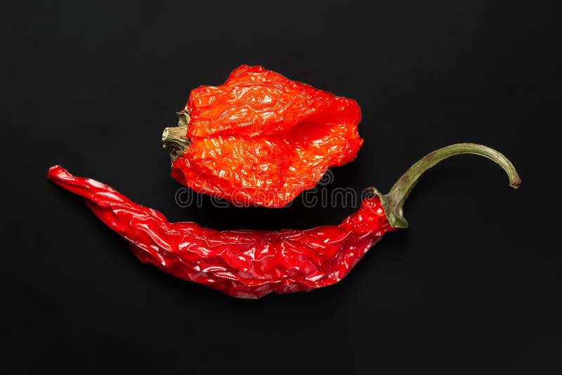 Pimenta quente. pimenta vermelha seca empilhada em fundo preto. vista superior. foco suave seletivo