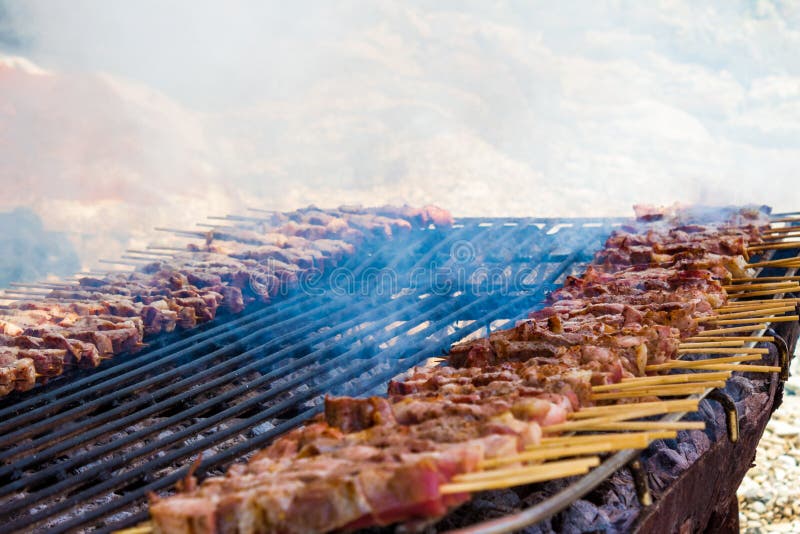Pinchos del pollo y del cordero en una parrilla simple, rústica presentada en la arena de una isla griega Ciérrese para arriba de imagenes de archivo Pinchos del pollo y del cordero en una parrilla simple, rústica presentada en la arena de una isla griega Ciérrese para arriba de imagenes de archivo