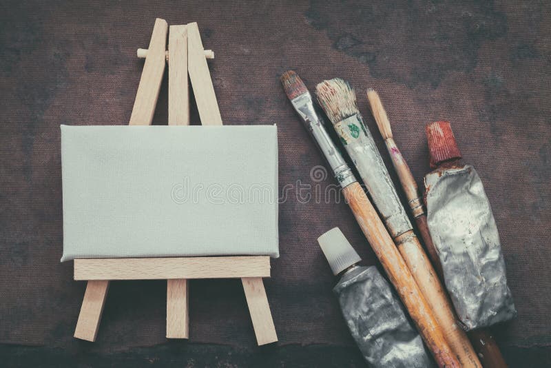 Pincéis do artista, tubos da pintura e armação pequena com close up da lona Vista superior fotos de stock Pincéis do artista, tubos da pintura e armação pequena com close up da lona Vista superior fotos de stock