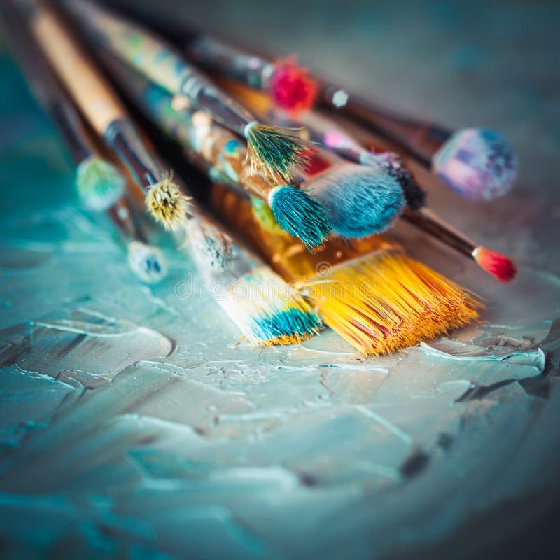 Paintbrushes on artist canvas covered with oil paints. Retro styled. Paintbrushes on artist canvas covered with oil paints. Retro styled.