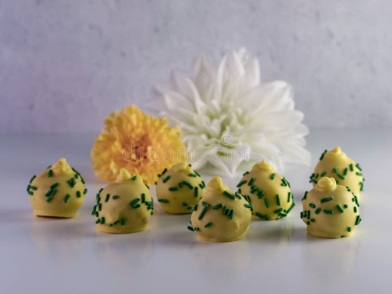 Pineapple upside down cake balls with yellow coating and green s