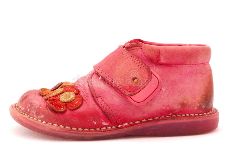 One old used and dirty pink baby child shoe. Image isolated on white studio background. One old used and dirty pink baby child shoe. Image isolated on white studio background.