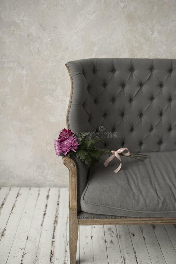 Pink Bouquet on a Grey Sofa. Bouquet Tied with Pink Ribbon Lying on a