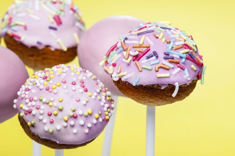 Pink cake pops on yellow background stock photos