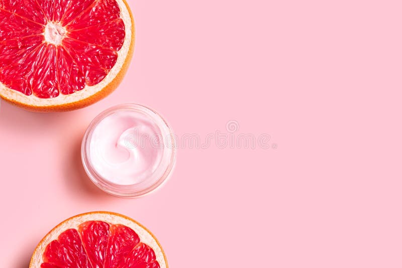 Pink cream moisturizer jar and grapefruit citrus slices stock photos
