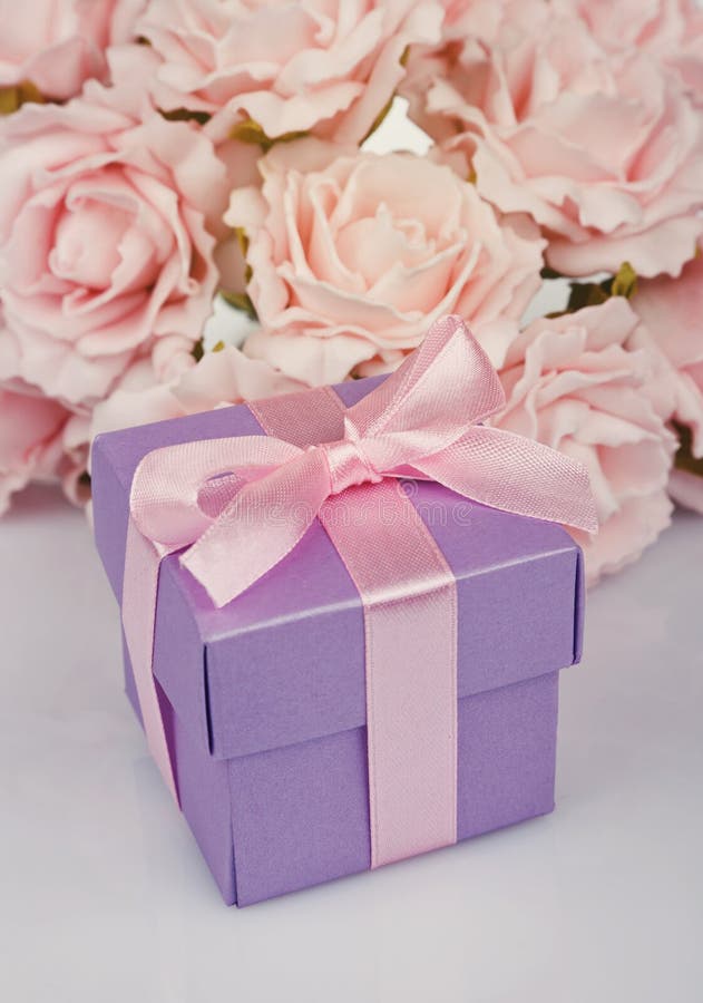 Pink Flowers And Gift Box With Red Ribbon And Bow On A White Ba Stock